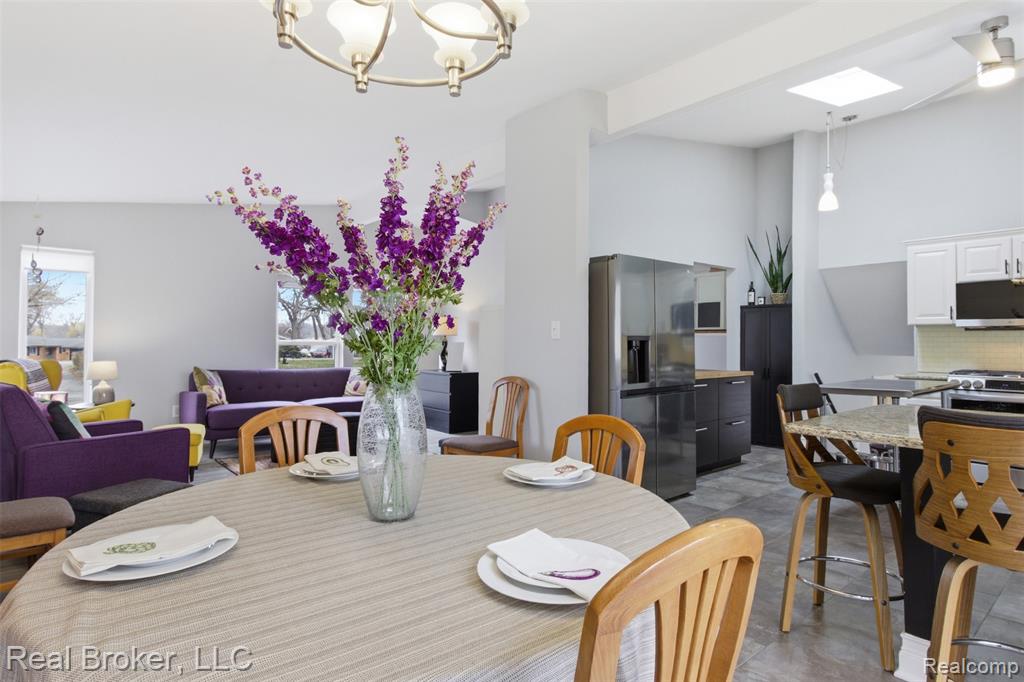 Dining space with hanging lights, lofted ceiling, and a skylight