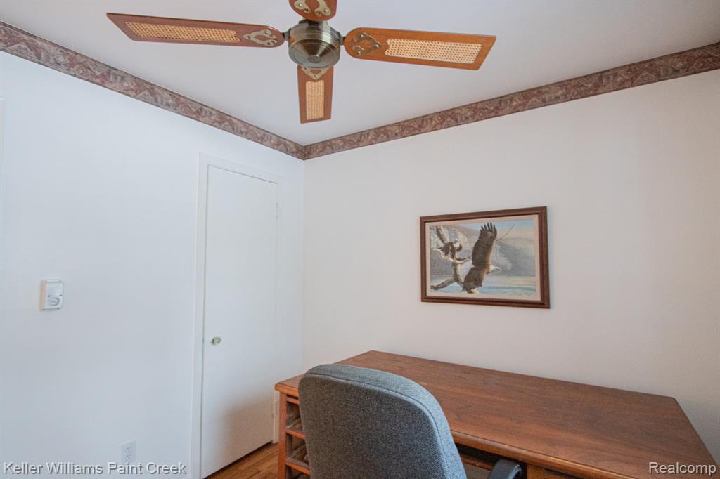 Home office with wood finished floors and ceiling fan