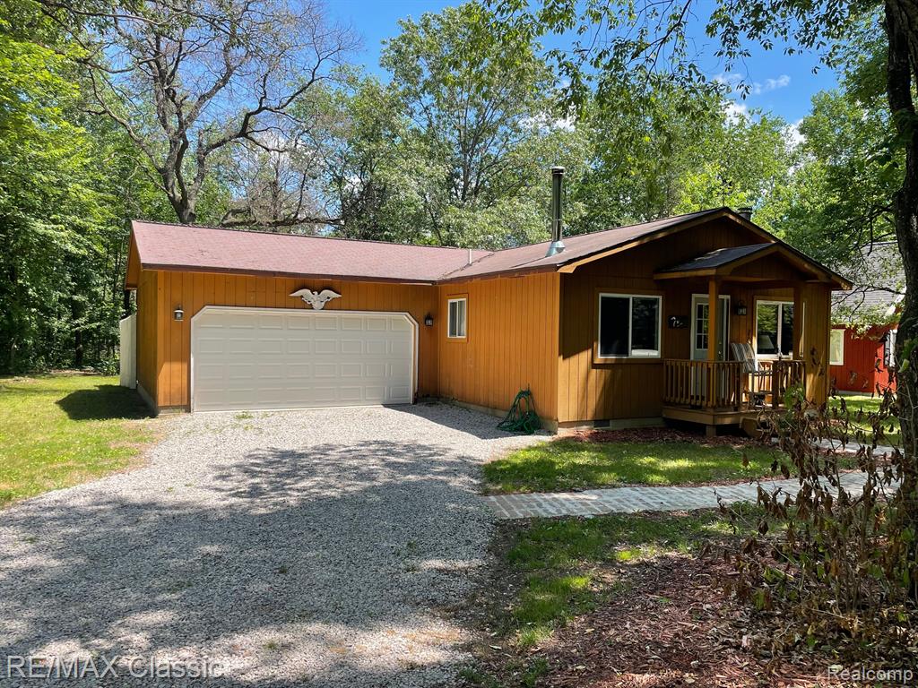 View of side of property featuring crawl space, a deck, and view of scattered trees