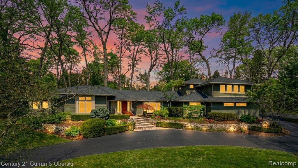 Prairie-style house with a chimney, a front yard, and driveway