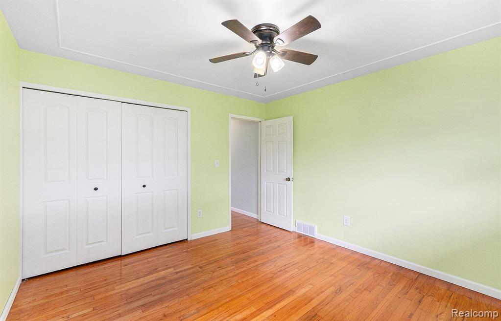 Unfurnished bedroom featuring light wood-type flooring, a closet, and a ceiling fan