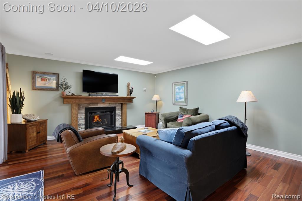 Living room featuring gas fireplace and skylights.