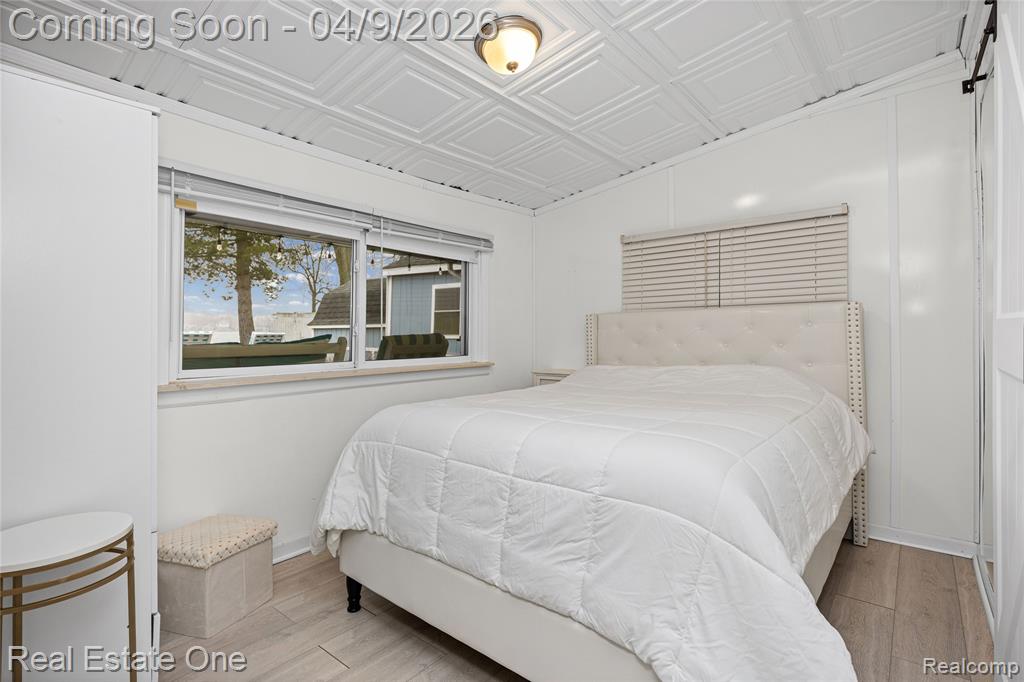 Bedroom with an ornate ceiling and light wood-style flooring