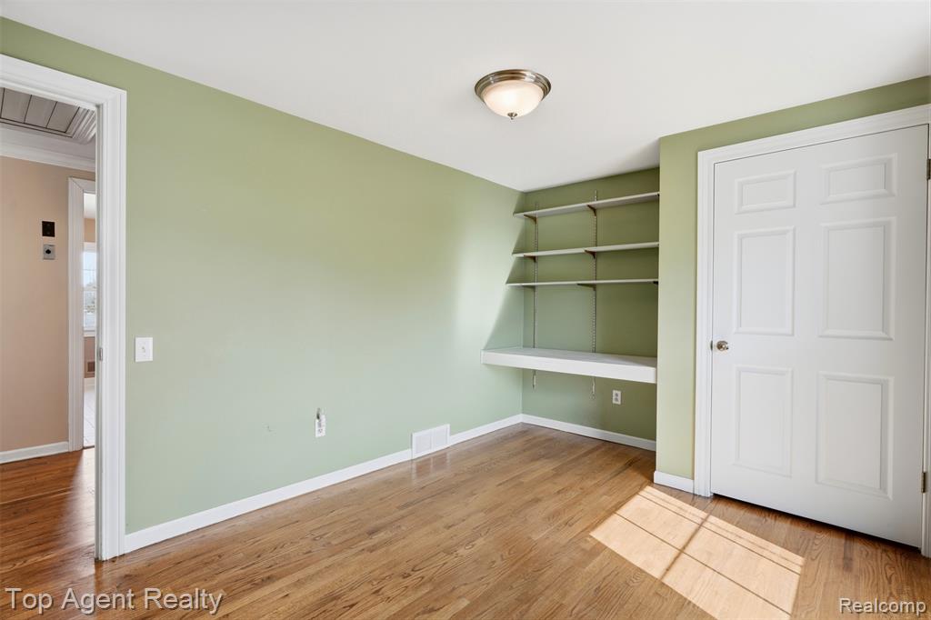 Spare room featuring baseboards and light wood-type flooring