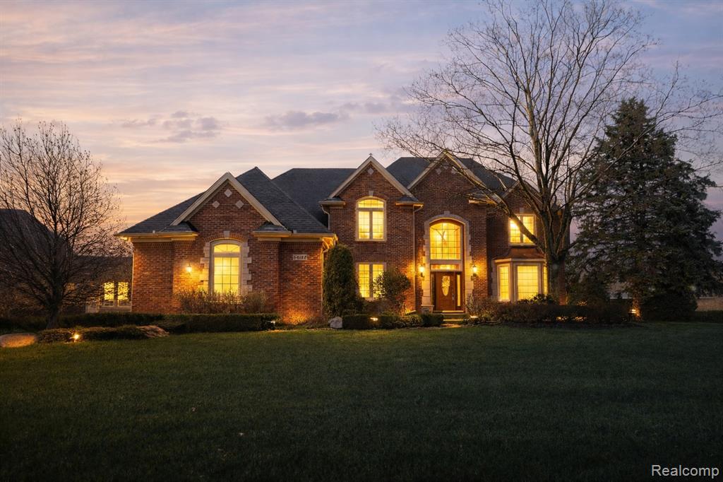 Traditional home with a front lawn and brick siding