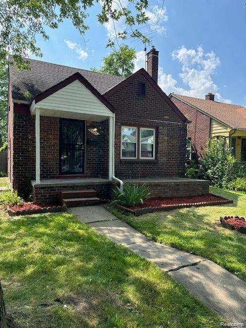 Photo for 8501 Roselawn Street, Detroit, MI 48204 - listing #20261003722 View of front of house featuring brick siding, a chimney, and a front yard
