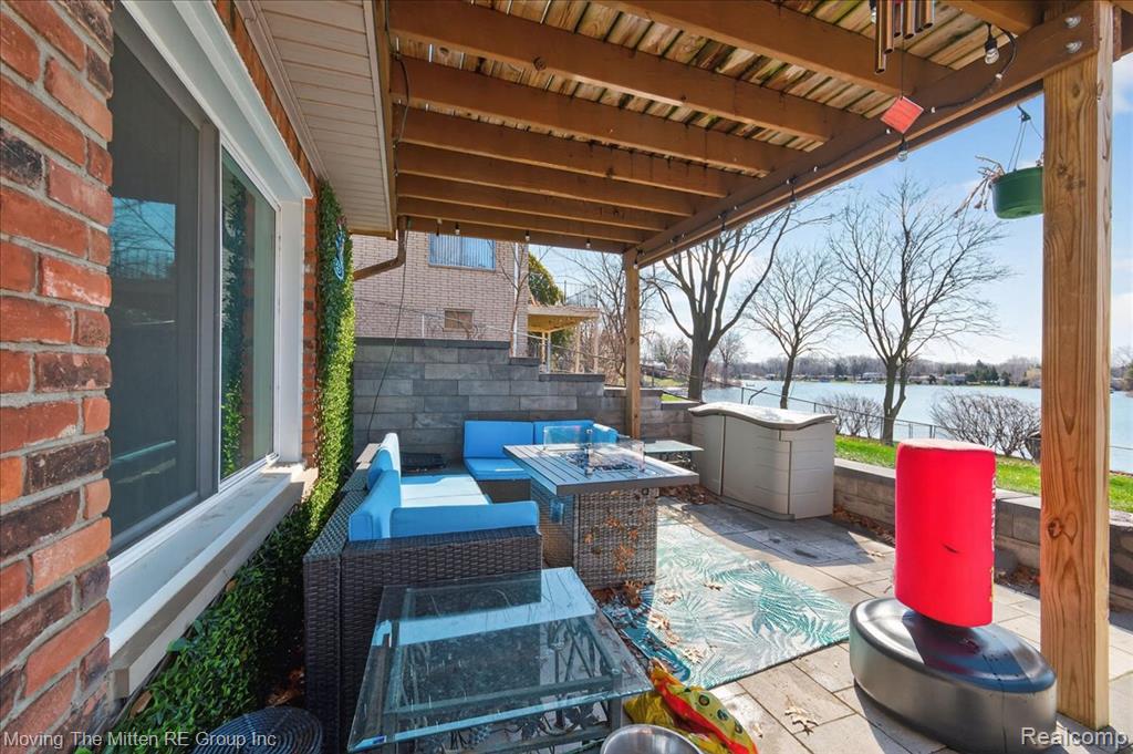 View of patio with an outdoor living space and a water view