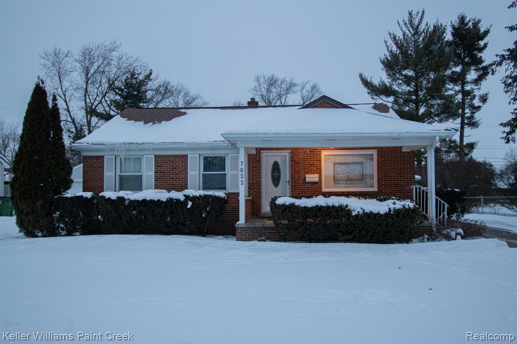 View of front of house with brick siding and a chimney