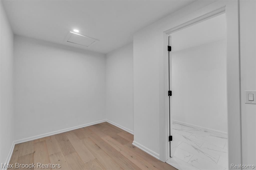 Spare room with attic access and light wood-style flooring