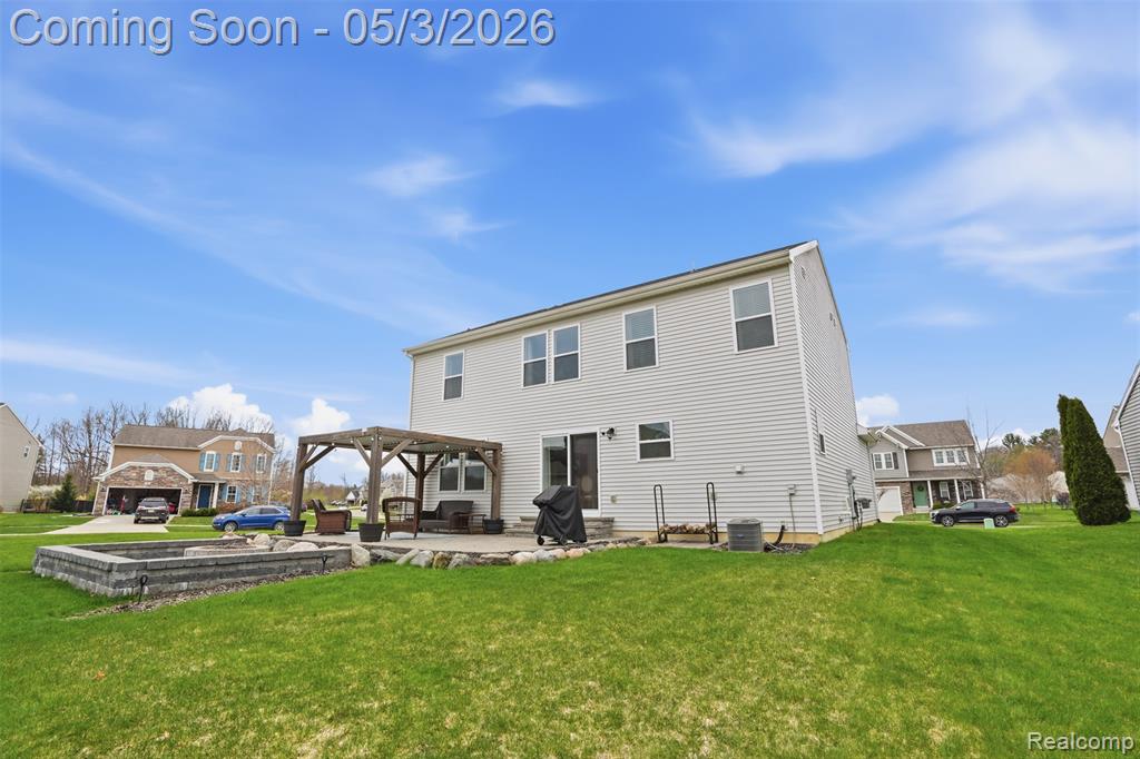 Rear view of property with a yard, a patio, and a pergola