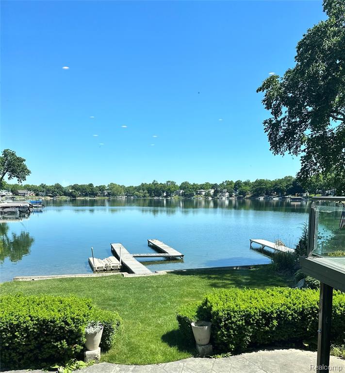 Dock area with a water view and a yard