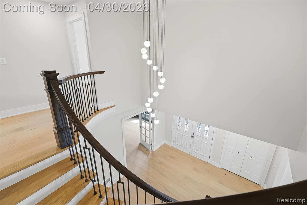 Stairs featuring wood finished floors and a high ceiling