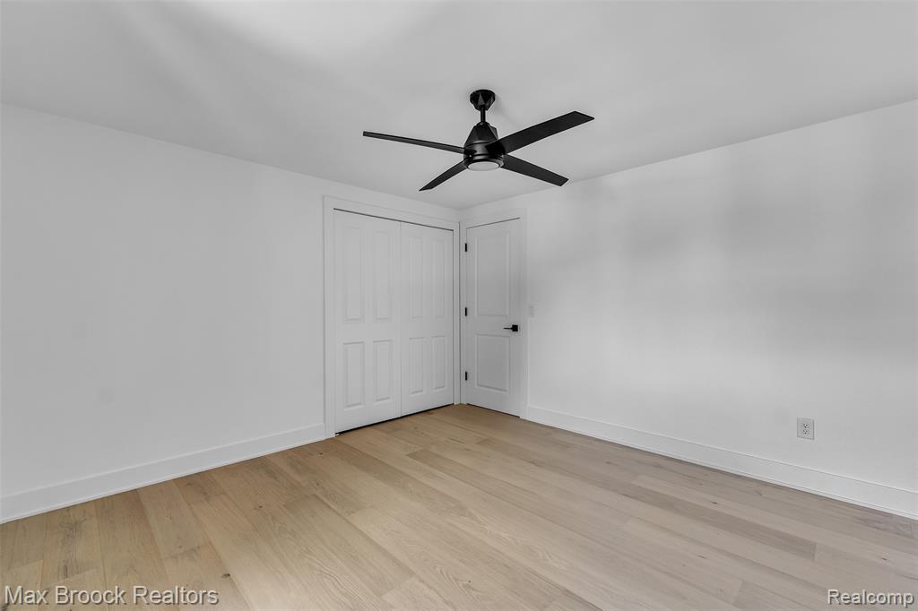 Unfurnished bedroom with light wood-style floors, a ceiling fan, and a closet
