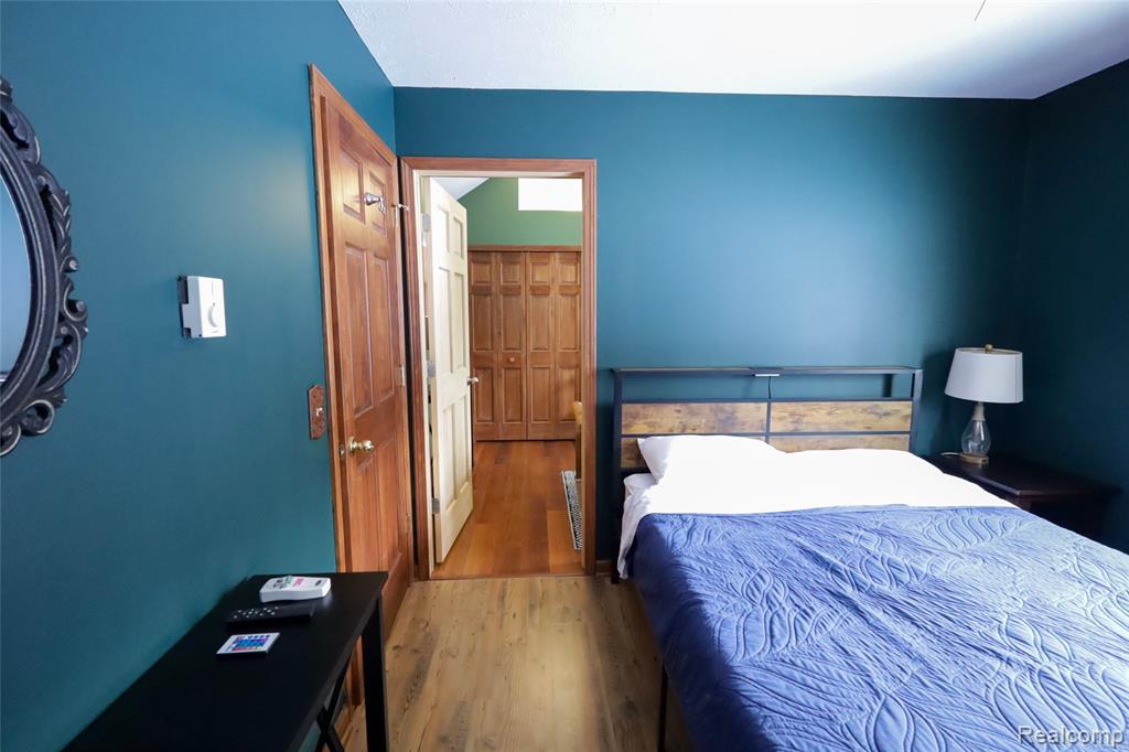 Bedroom with wood finished floors and a closet