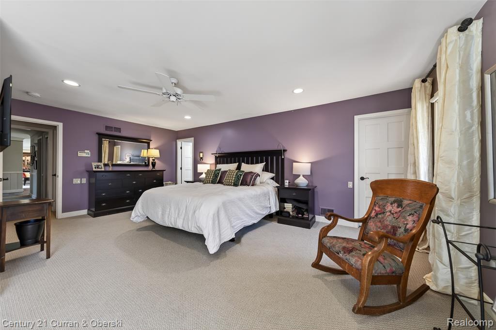 Bedroom with light colored carpet, ceiling fan, and recessed lighting