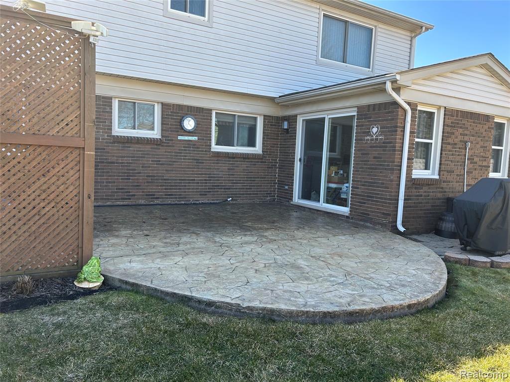 Rear view of property with a patio and brick siding