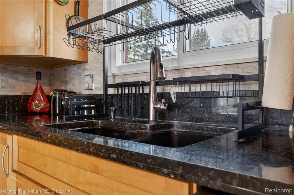 Kitchen featuring dark stone countertops and backsplash