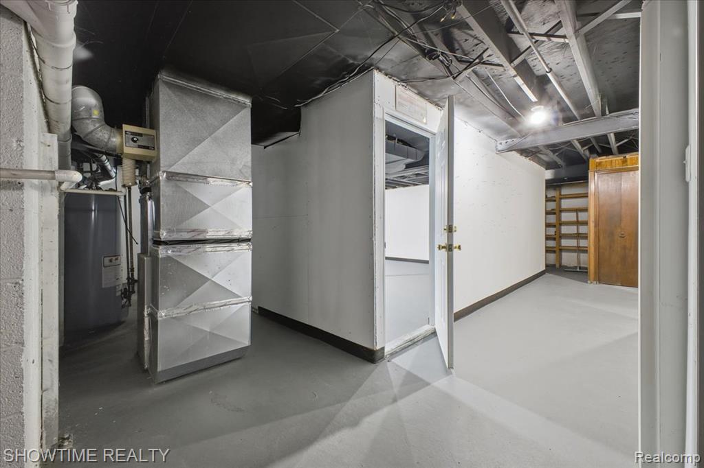 Unfinished below grade area featuring heating unit and water heater