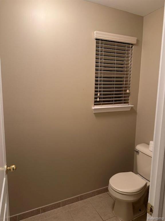 Bathroom featuring a shower stall and light tile patterned flooring