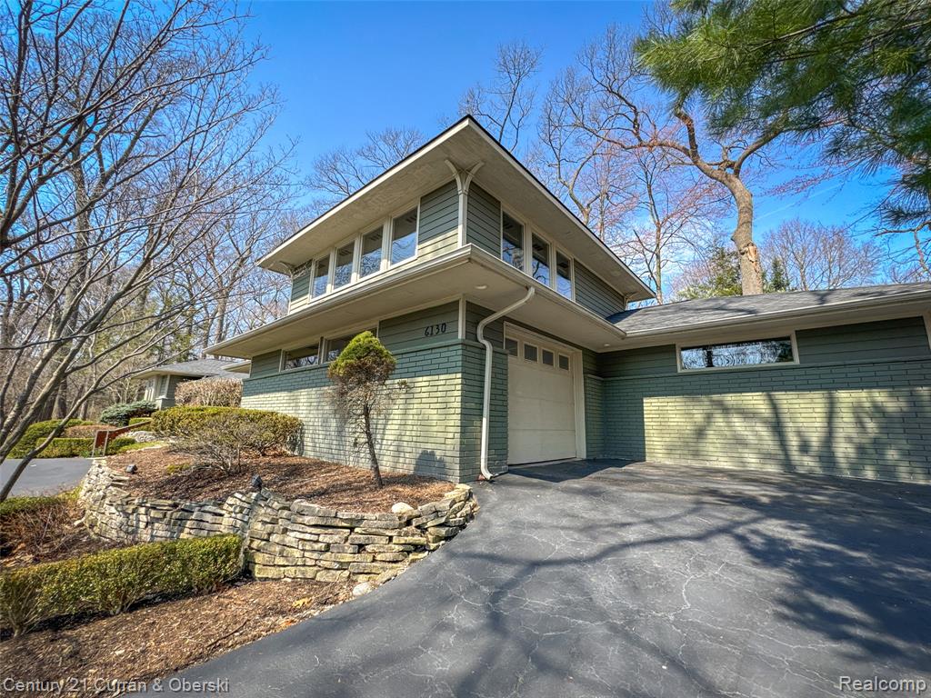 View of front of property with asphalt driveway and brick siding
