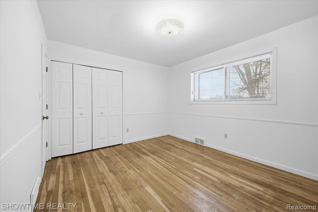 Unfurnished bedroom featuring a closet and light wood-style flooring
