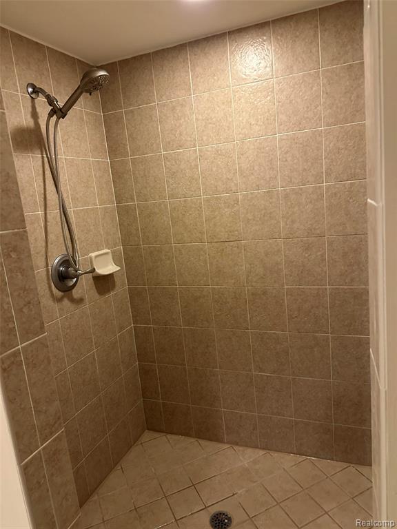 Full bathroom featuring vanity, a tub with jets, and light tile patterned flooring