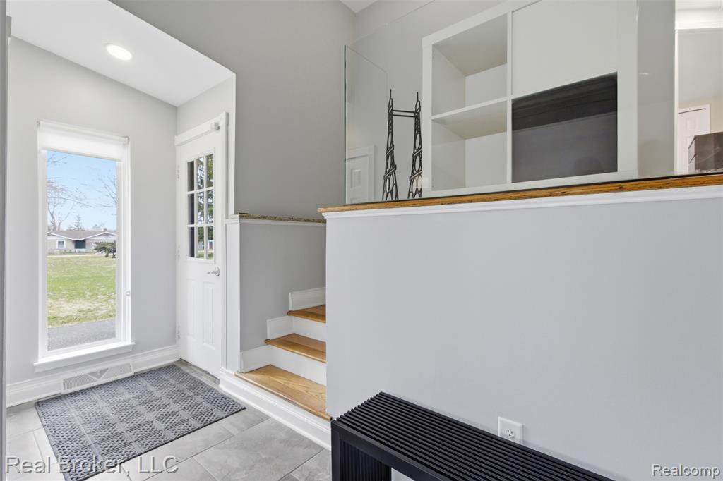 Doorway to outside with stairs and baseboards