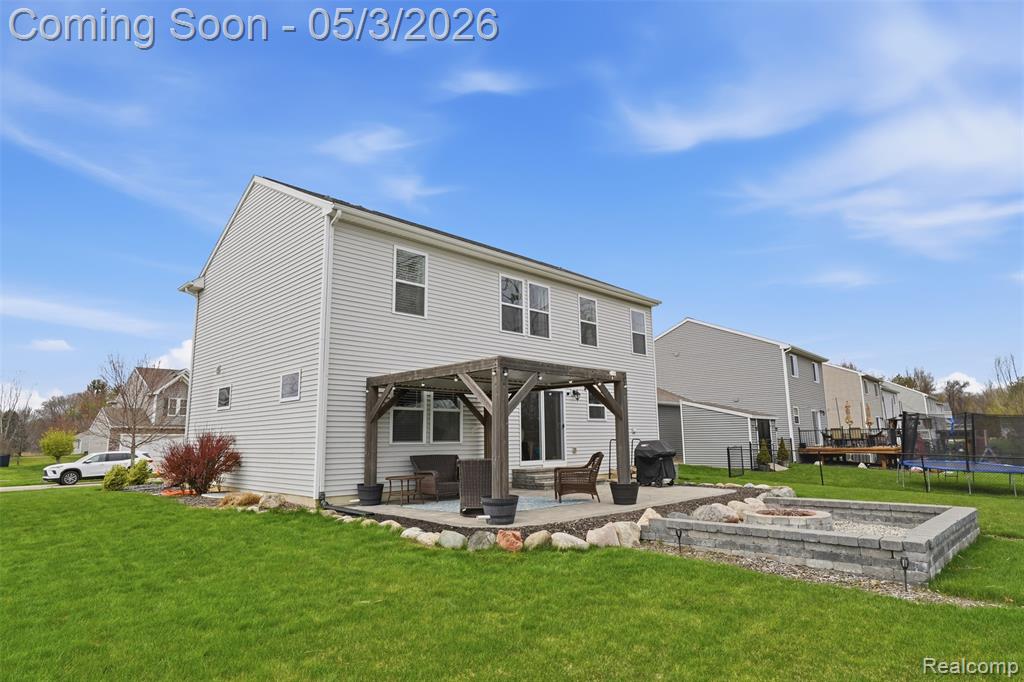Rear view of property featuring a pergola, an outdoor fire pit, and a patio