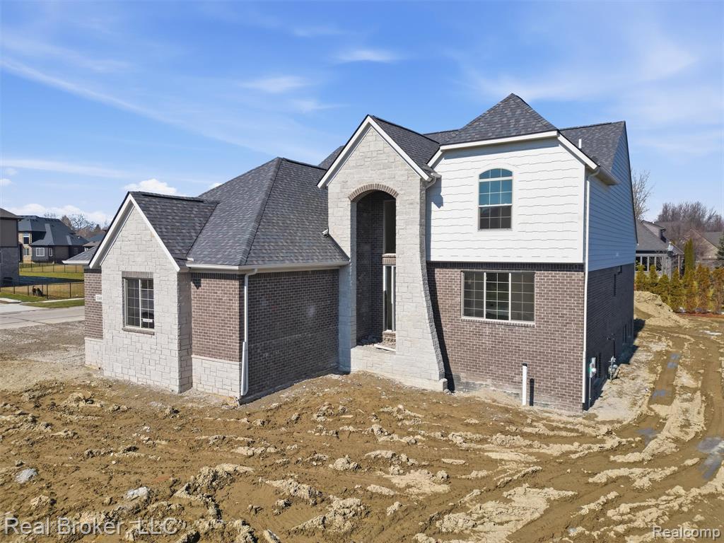 View of front of house with brick siding and a shingled roof