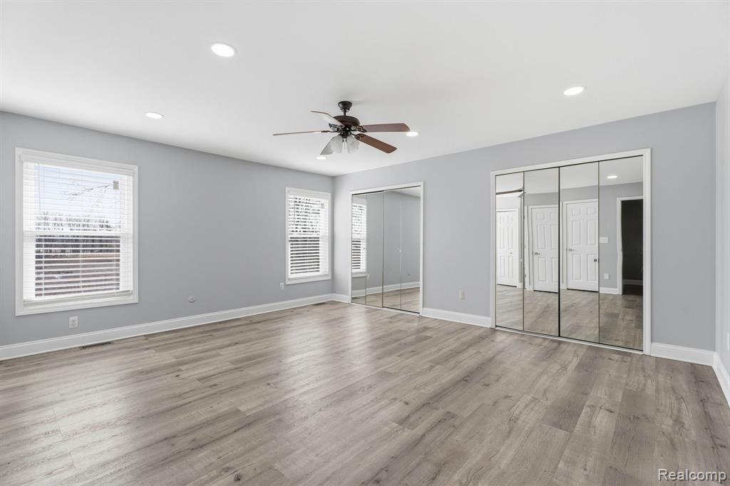 Unfurnished bedroom featuring two closets, a ceiling fan, recessed lighting, and light wood-type flooring