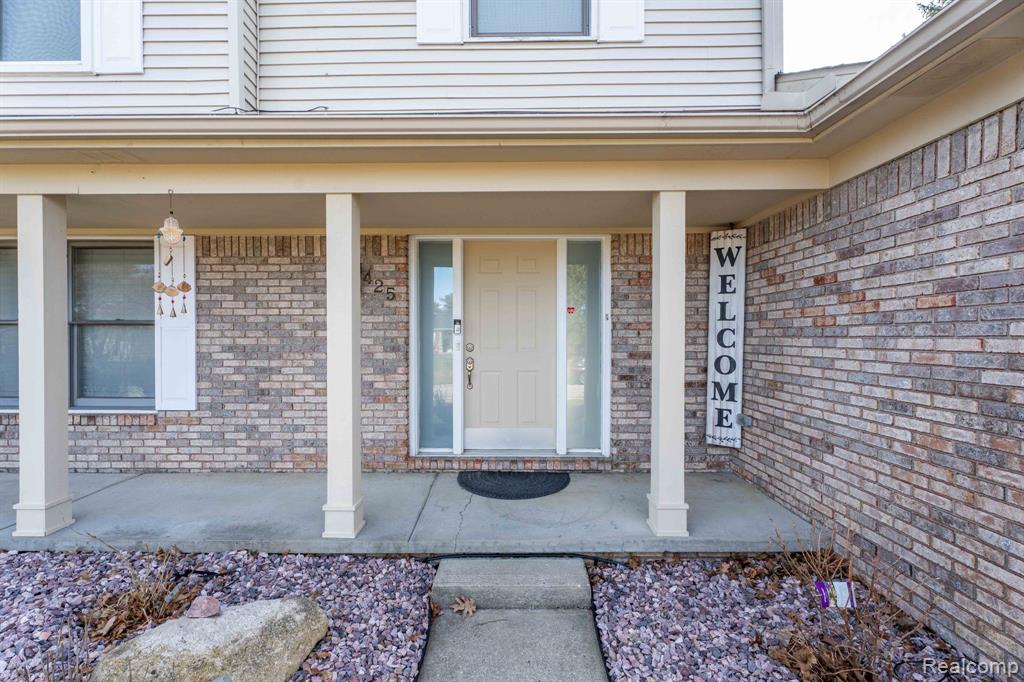 Property entrance with a porch and brick siding