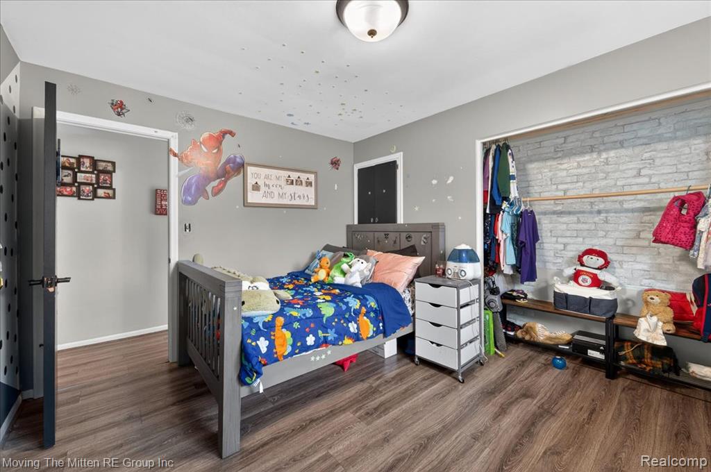 Bedroom featuring dark wood-style flooring and baseboards