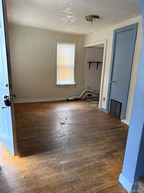 Laundry area featuring baseboards and dark wood-style flooring