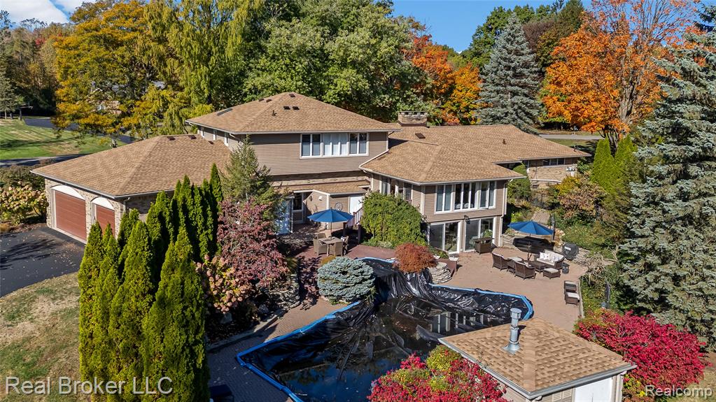 View of subject property featuring a tree filled landscape