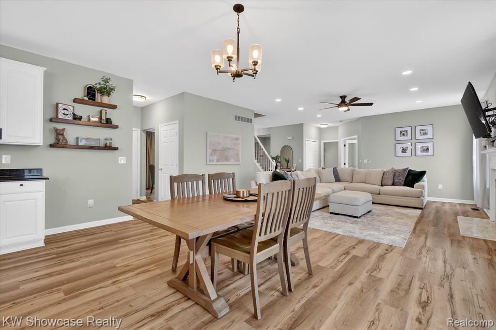 Kitchen featuring white cabinetry, stainless steel appliances, a kitchen island, pendant lighting, and dark stone counters