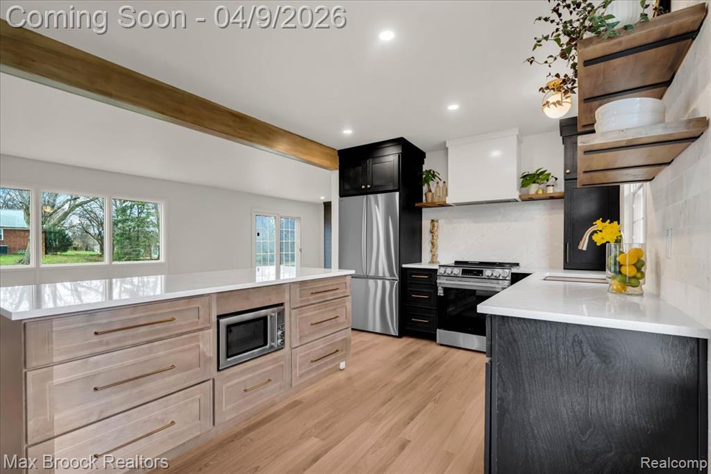 Kitchen featuring open shelves, stainless steel appliances, dual tone cabinetry, light stone countertops, and recessed lighting