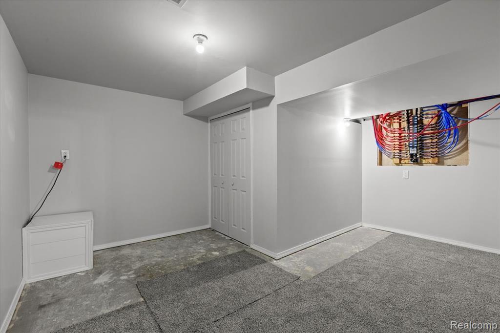 View of snow covered exterior featuring a garage and brick siding