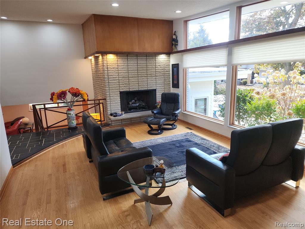 Living area with wood finished floors, a fireplace, and recessed lighting