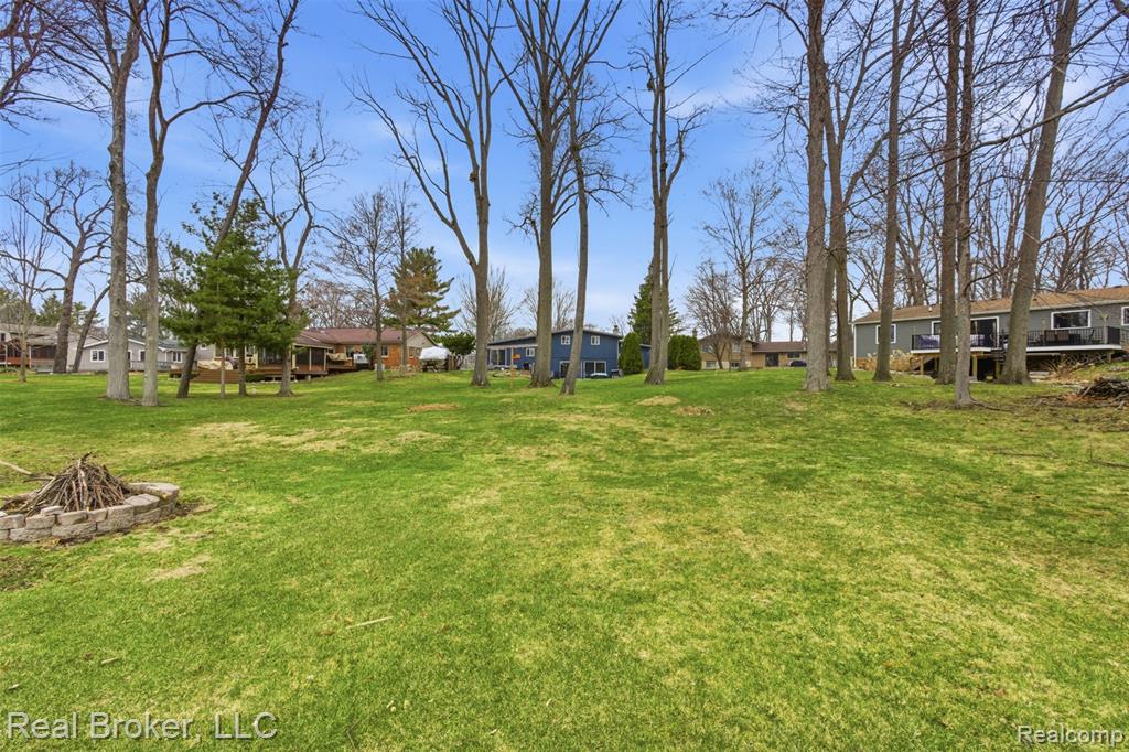 View of grassy yard featuring a fire pit