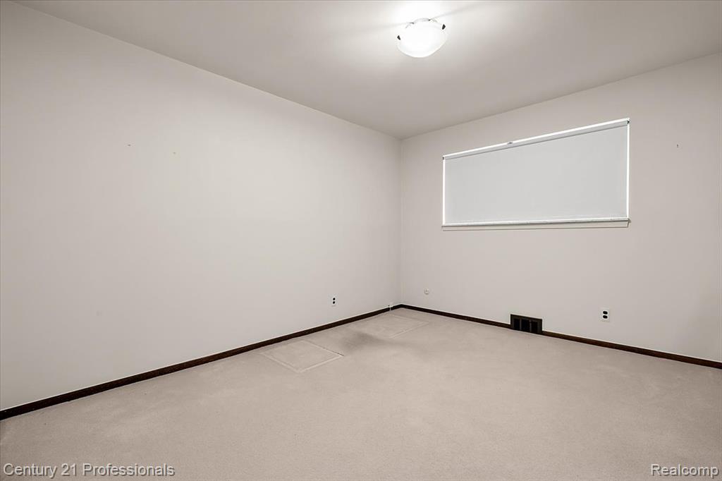 Unfurnished room with light colored carpet and baseboards
