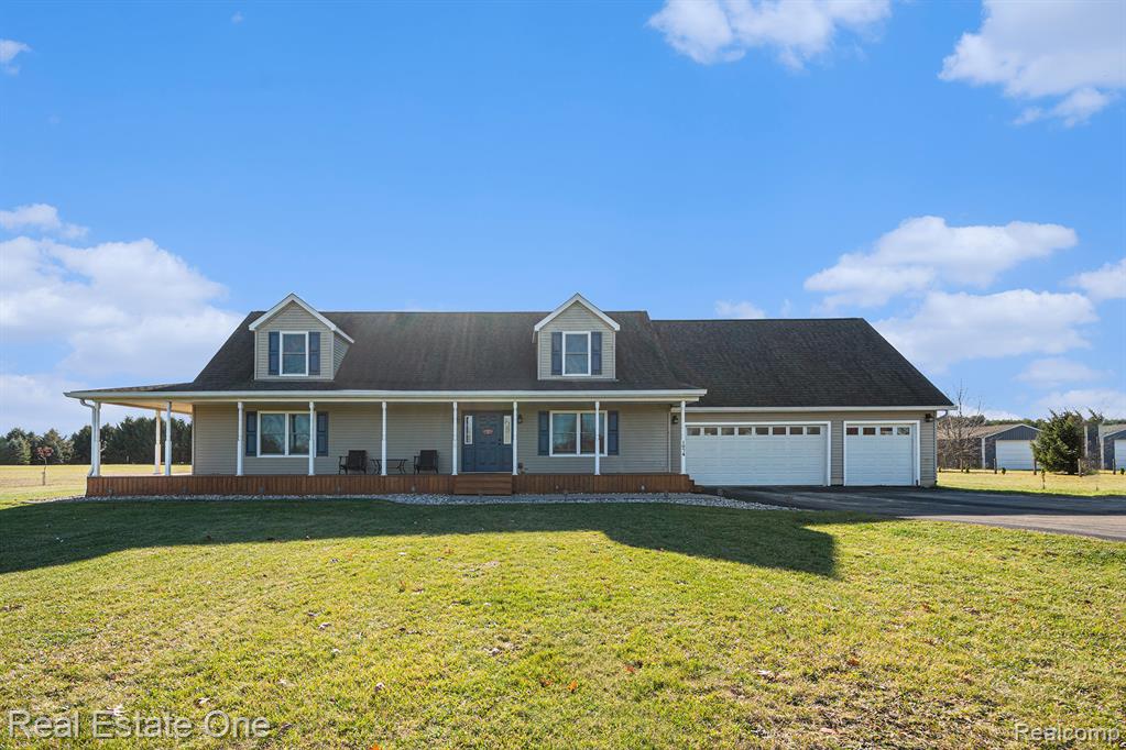 Photo for 1074 Deer Valley Valley, Manchester, MI 48158 - listing #20251053963 View of front of property with covered porch, a front yard, driveway, and an attached garage