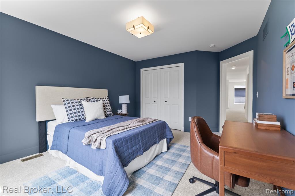 Carpeted bedroom featuring a closet and an office area