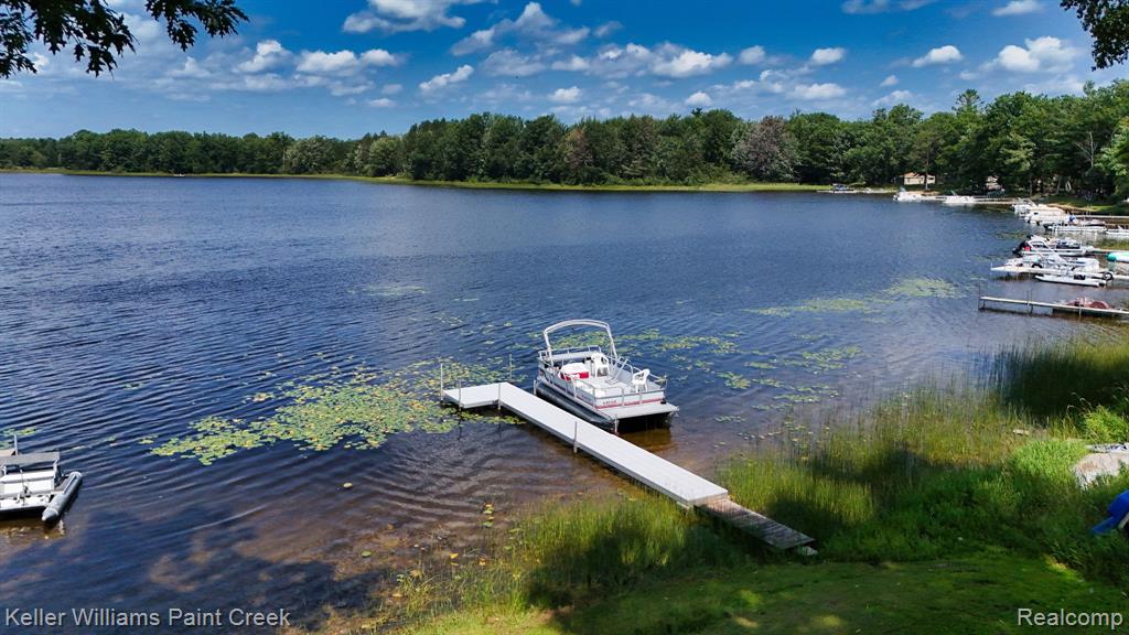 Lakefront property featuring a private dock, boat access, and natural wooded surroundings