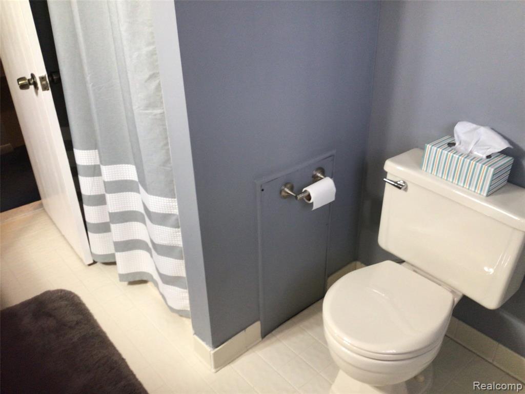 Full bathroom featuring a shower with shower curtain and toilet