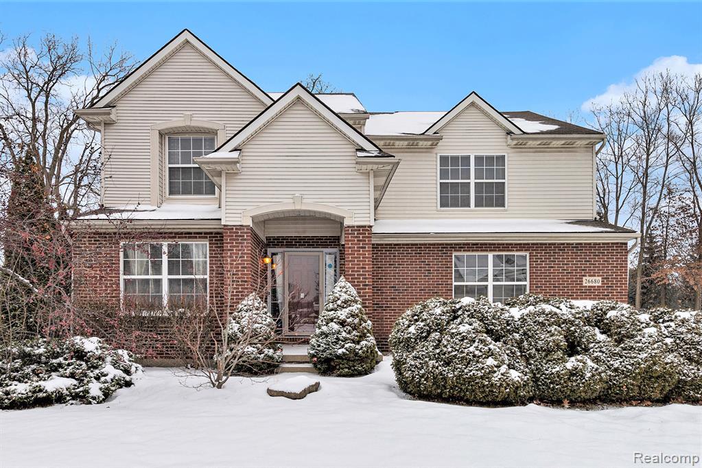 Traditional home with brick siding and a front lawn