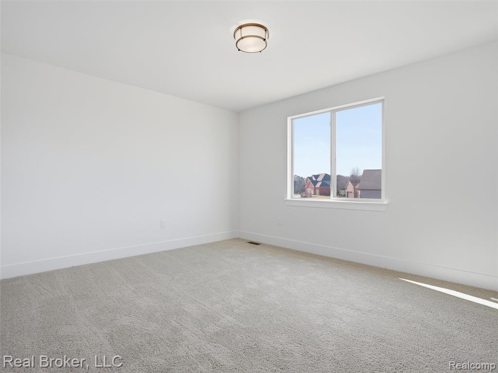 Carpeted empty room featuring baseboards