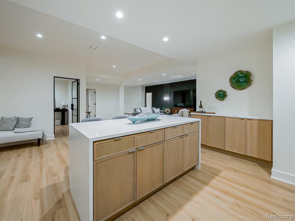 Kitchen featuring light brown cabinetry, open floor plan, recessed lighting, and light wood finished floors