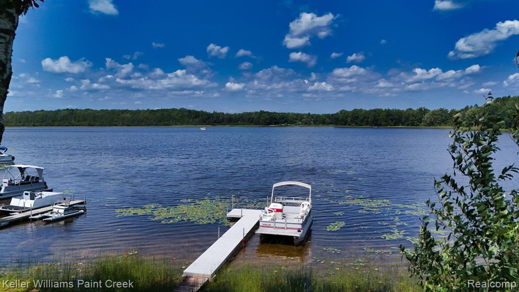 Expansive waterfront setting featuring a private dock, tranquil lake, and surrounding natural foliage