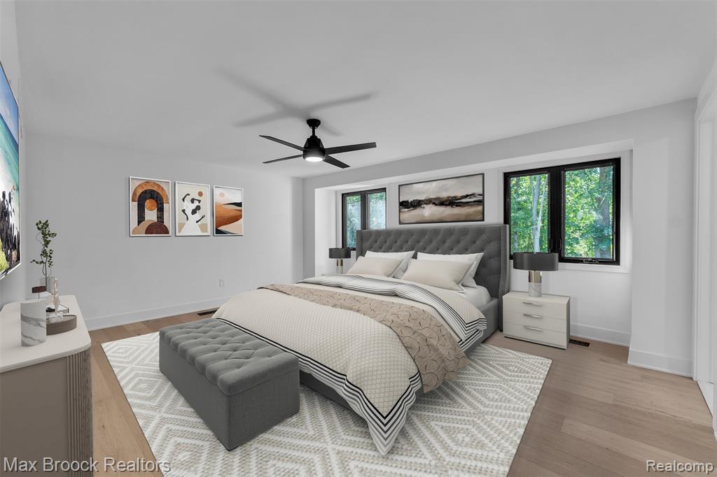 VIRTUALLY STAGED Bedroom with multiple windows, light wood-style floors, and a ceiling fan