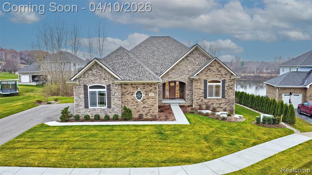 View of front of home with a front yard and brick siding